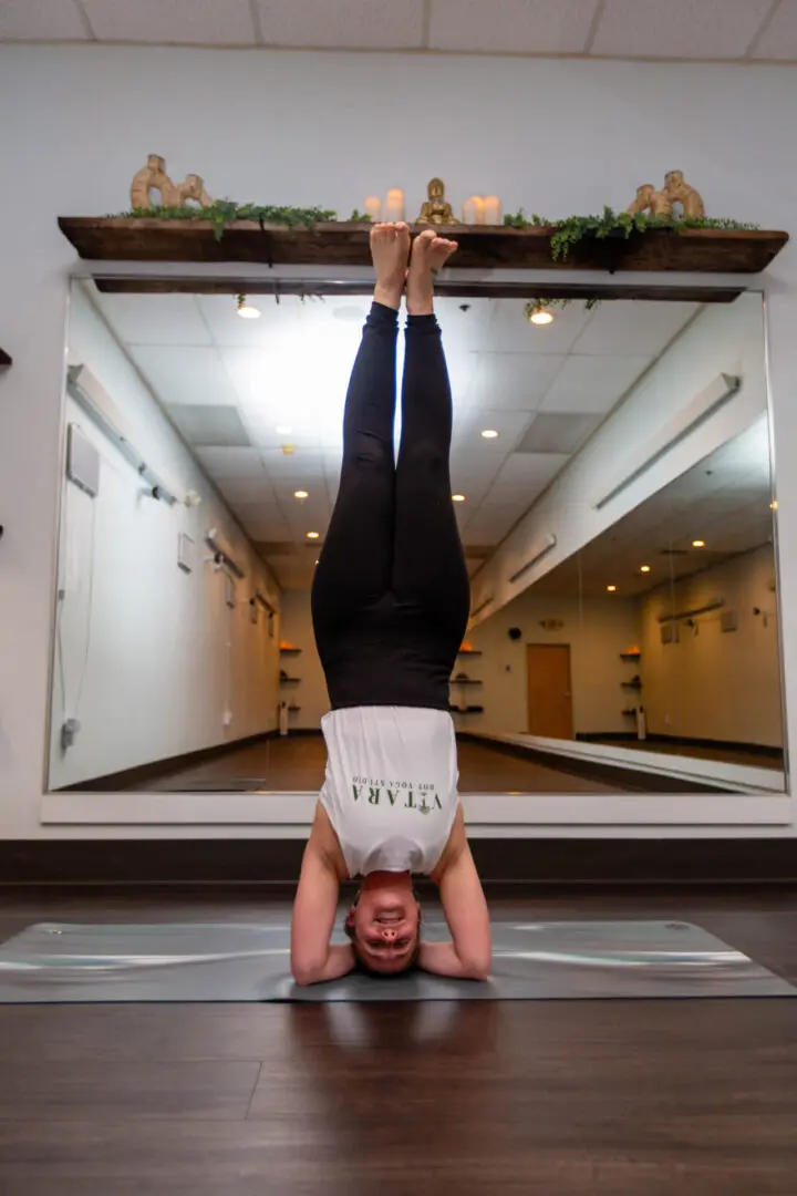 Person doing headstand on yoga mat