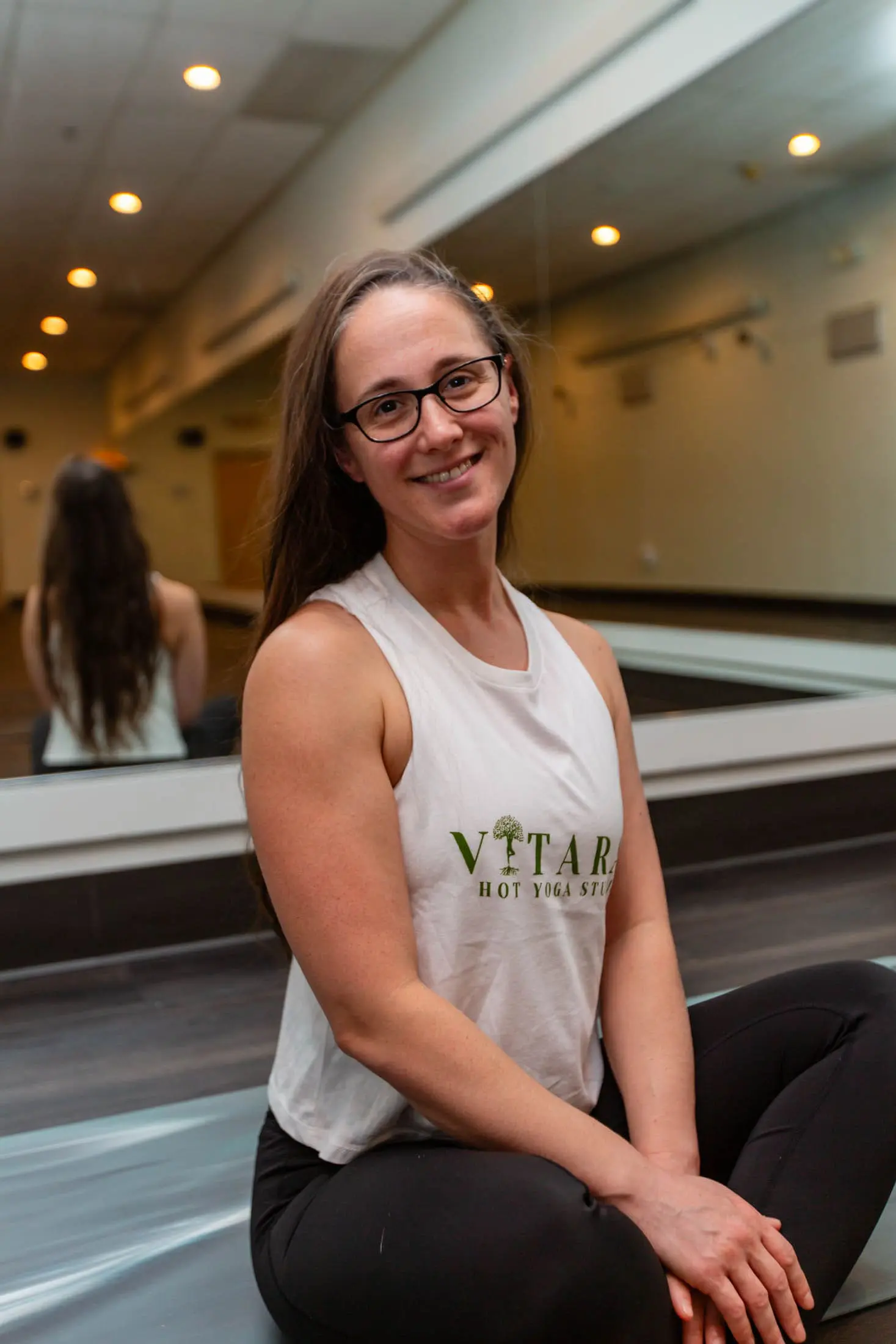Vitara Hot Yoga teacher supporting students during class